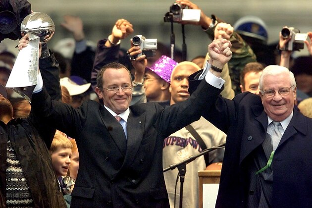 BALTIMORE, :  Baltimore Ravens owner Art Modell (R) celebrates with his son and team President David (L) on stage with the Vince Lombardi Trophy during a victory parade and celebration for the Super Bowl XXXV champions in front of City Hall 30 January 2001 in Baltimore, Maryland. (Photo credit should read TIM SLOAN/AFP/Getty Images)