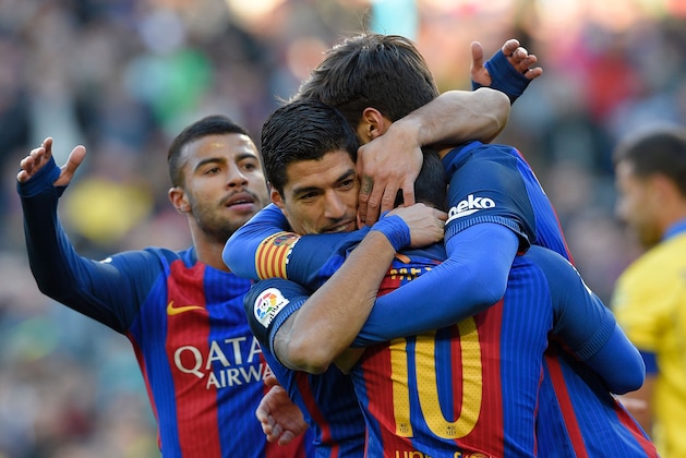 Barcelona's Uruguayan forward Luis Suarez hugs teammates after scoring a goal during the Spanish league football match FC Barcelona vs UD Las Palmas at the Camp Nou stadium in Barcelona on January 14, 2017. / AFP / LLUIS GENE        (Photo credit should read LLUIS GENE/AFP/Getty Images)