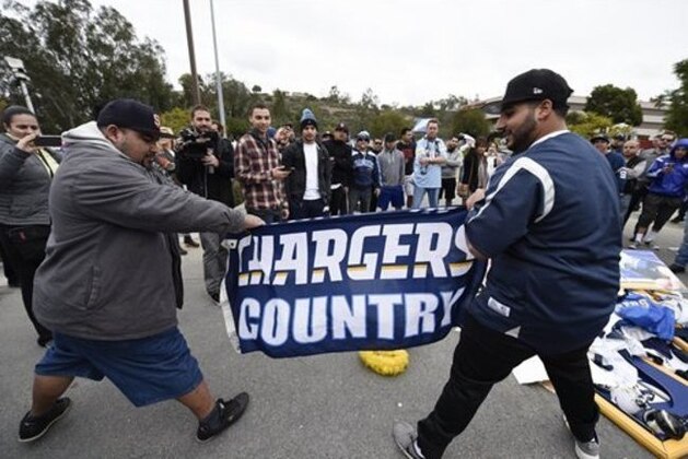 A San Diego Chargers fans rip a Chargers flag in front of Chargers headquarters after the team announced that it will move to Los Angeles, Thursday Jan. 12, 2017, in San Diego. (AP Photo/Denis Poroy)