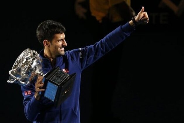 Novak Djokovic of Serbia waves as he walks around Rod Laver Arena after defeating Andy Murray of Britain in the men's singles final at the Australian Open tennis championships in Melbourne, Australia, Sunday, Jan. 31, 2016.(AP Photo/Rafiq Maqbool)