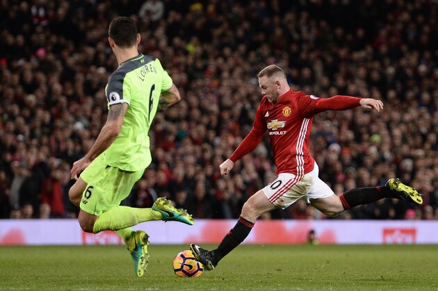Manchester United's English striker Wayne Rooney (R) has an unsuccessful shot during the English Premier League football match between Manchester United and Liverpool at Old Trafford in Manchester, north west England, on January 15, 2017.
The game finished 1-1. / AFP / Oli SCARFF / RESTRICTED TO EDITORIAL USE. No use with unauthorized audio, video, data, fixture lists, club/league logos or 'live' services. Online in-match use limited to 75 images, no video emulation. No use in betting, games or single club/league/player publications.  /         (Photo credit should read OLI SCARFF/AFP/Getty Images)