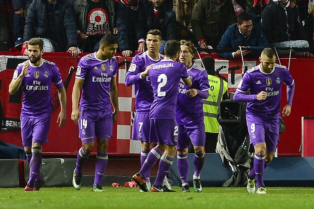 Real Madrid's Portuguese forward Cristiano Ronaldo (3rdL) celebrates after scoring during the Spanish league football match Sevilla FC vs Real Madrid CF at the Ramon Sanchez Pizjuan stadium in Sevilla on January 15, 2017. / AFP / CRISTINA QUICLER        (Photo credit should read CRISTINA QUICLER/AFP/Getty Images)