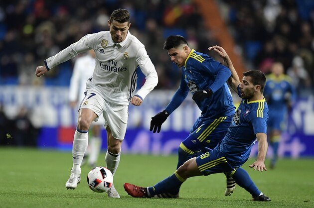 Real Madrid's Portuguese forward Cristiano Ronaldo (L) vies with Celta Vigo's Argentinian defender Facundo Roncaglia (C) and Celta Vigo's defender Jonny Castro during the Spanish Copa del Rey (King's Cup) quarter-final first leg football match Real Madrid CF vs RC Celta de Vigo at the Santiago Bernabeu stadium in Madrid on January 18, 2017. / AFP / JAVIER SORIANO        (Photo credit should read JAVIER SORIANO/AFP/Getty Images)