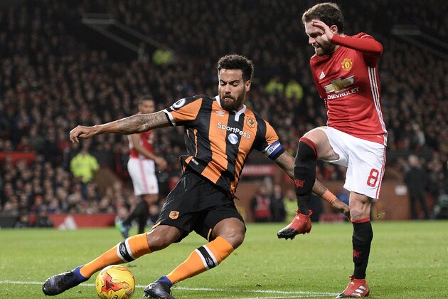 Hull City's English midfielder Tom Huddlestone (L) clears the ball from the path of Manchester United's Spanish midfielder Juan Mata during the EFL (English Football League) Cup semi-final football match between Manchester United and Hull City at Old Trafford in Manchester, north west England on January 10, 2017. / AFP / Oli SCARFF / RESTRICTED TO EDITORIAL USE. No use with unauthorized audio, video, data, fixture lists, club/league logos or 'live' services. Online in-match use limited to 75 images, no video emulation. No use in betting, games or single club/league/player publications.  /         (Photo credit should read OLI SCARFF/AFP/Getty Images)