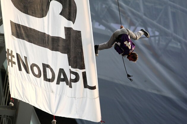 MINNEAPOLIS, MN - JANUARY 1: A protestor wearing a Brett Farve jersey dangles upside down above Minnesota Vikings and Chicago Bears football game on January 1, 2017 at US Bank Stadium in Minneapolis, Minnesota. Two protesters hung a banner in opposition to the Dakota Access Pipeline from the rafters of the stadium in the second quarter of the game. (Photo by Adam Bettcher/Getty Images)