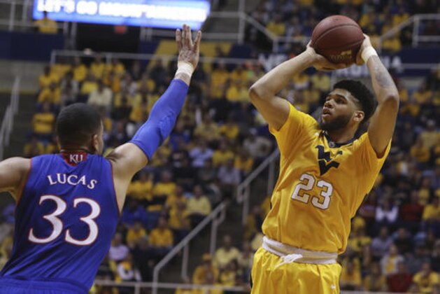 West Virginia forward Esa Ahmad (23) takes a jump shot as Kansas forward Landen Lucas (33) attempts to block him during the second half of an NCAA college basketball game, Tuesday, Jan. 24, 2017, in Morgantown, W.Va. West Virginia defeated Kansas 85-69. (AP Photo/Raymond Thompson)