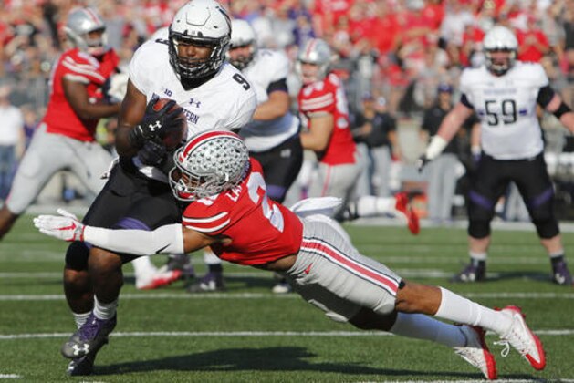Northwestern running back Garrett Dickerson, left, tries to run around Ohio State cornerback Marshon Lattimore during the first half of an NCAA college football game Saturday, Oct. 29, 2016, in Columbus, Ohio. (AP Photo/Jay LaPrete)