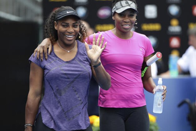 United States' Serena Williams, left, waves to the crowd as she walks onto the court with her sister Venus during an exhibition event ahead of the ASB Classic tennis tournament in Auckland, New Zealand, Sunday, Jan. 1, 2017. (Doug Sherring/New Zealand Herald via AP)