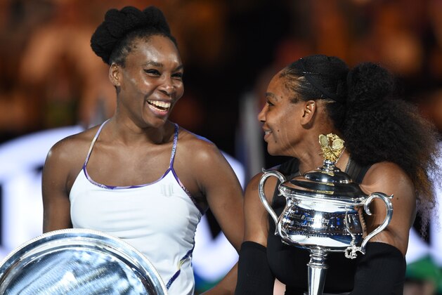 Runner up Venus Williams of the US (L) laughs with winner Serena Williams of the US during the awards ceremony following the women's singles final on day 13 of the Australian Open tennis tournament in Melbourne on January 28, 2017. / AFP / PAUL CROCK / IMAGE RESTRICTED TO EDITORIAL USE - STRICTLY NO COMMERCIAL USE        (Photo credit should read PAUL CROCK/AFP/Getty Images)