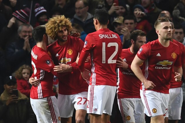 Manchester United's Belgian midfielder Marouane Fellaini (2L) celebrates with teammates after scoring his team's first goal during the English FA Cup fourth round football match between Manchester United and Wigan Athletic at Old Trafford in Manchester, north west England, on January 29, 2017. / AFP / Paul ELLIS / RESTRICTED TO EDITORIAL USE. No use with unauthorized audio, video, data, fixture lists, club/league logos or 'live' services. Online in-match use limited to 75 images, no video emulation. No use in betting, games or single club/league/player publications.  /         (Photo credit should read PAUL ELLIS/AFP/Getty Images)