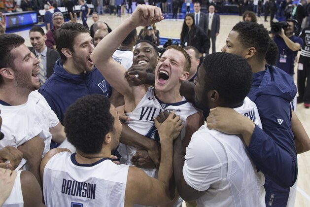 PHILADELPHIA, PA - JANUARY 29: Donte DiVincenzo #10 of the Villanova Wildcats celebrates with Jalen Brunson #1, Eric Paschall #4, Darryl Reynolds #45, and the rest of his team after tipping in the game winning basket as time expired against the Virginia Cavaliers at the Wells Fargo Center on January 29, 2017 in Villanova, Pennsylvania. The Wildcats defeated the Cavaliers 61-59. (Photo by Mitchell Leff/Getty Images)