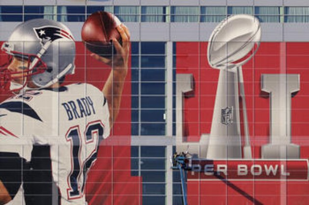 Workers attach a sign to the front of NRG Stadium as preparations continue for the NFL Super Bowl 51 football game Sunday, Jan. 29, 2017, in Houston. (AP Photo/Charlie Riedel)
