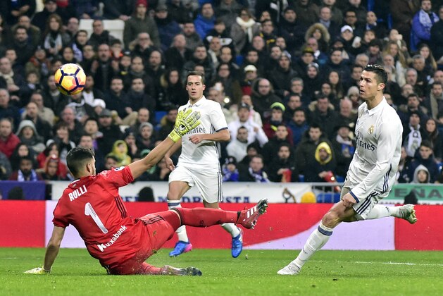 Real Madrid's Portuguese forward Cristiano Ronaldo (R) shoots in front of Real Sociedad's Argentinian goalkeeper Geronimo Rulli to score a goal during the Spanish league football match Real Madrid CF vs Real Sociedad at the Santiago Bernabeu stadium in Madrid on January 29, 2017. / AFP / GERARD JULIEN        (Photo credit should read GERARD JULIEN/AFP/Getty Images)