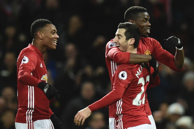 Manchester United's Armenian midfielder Henrikh Mkhitaryan (2R) celebrates scoring their third goal with Manchester United's French midfielder Paul Pogba (R) and Manchester United's French striker Anthony Martial (L) during the English Premier League football match between Manchester United and Sunderland at Old Trafford in Manchester, north west England, on December 26, 2016. / AFP / Oli SCARFF / RESTRICTED TO EDITORIAL USE. No use with unauthorized audio, video, data, fixture lists, club/league logos or 'live' services. Online in-match use limited to 75 images, no video emulation. No use in betting, games or single club/league/player publications.  /         (Photo credit should read OLI SCARFF/AFP/Getty Images)