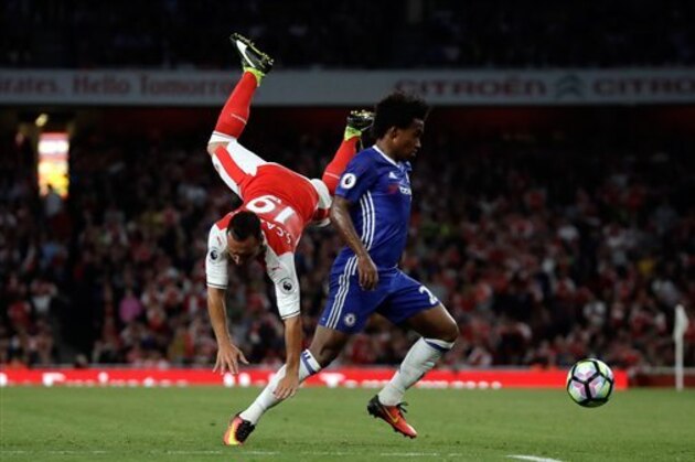 Arsenal's Santi Cazorla falls after colliding with Chelsea's Willian, right, during the English Premier League soccer match between Arsenal and Chelsea at the Emirates Stadium in London, Saturday, Sept. 24, 2016. (AP Photo/Matt Dunham)
