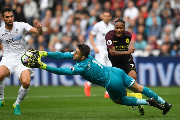 SWANSEA, WALES - SEPTEMBER 24: Swansea City goalkeeper Lukasz Fabianski saves from Raheem Sterling of Manchester City (r) during the Premier League match between Swansea City and Manchester City at the Liberty Stadium on September 24, 2016 in Swansea, Wales.  (Photo by Stu Forster/Getty Images)
