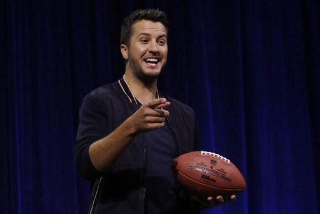 Luke Bryan poses with a football at a news conference for the NFL Super Bowl 51 football game Thursday, Feb. 2, 2017, in Houston. (AP Photo/Morry Gash)
