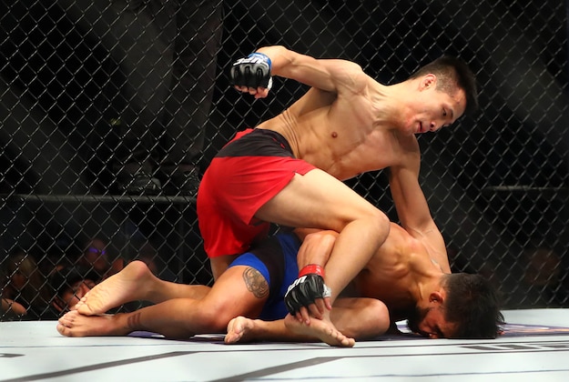 Feb 4, 2017; Houston, TX, USA; Chan Sung Jung (blue gloves) defeats Dennis Bermudez by knockout during UFC Fight Night at Toyota Center. Mandatory Credit: Mark J. Rebilas-USA TODAY Sports