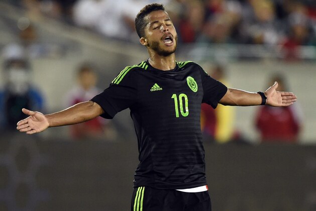 Giovani Dos Santos of Mexico reacts to a tackle during a friendly football match against Ecuador at the LA Memorial Coliseum in Los Angeles, California on March 28, 2015.        AFP PHOTO/ MARK RALSTON        (Photo credit should read MARK RALSTON/AFP/Getty Images)