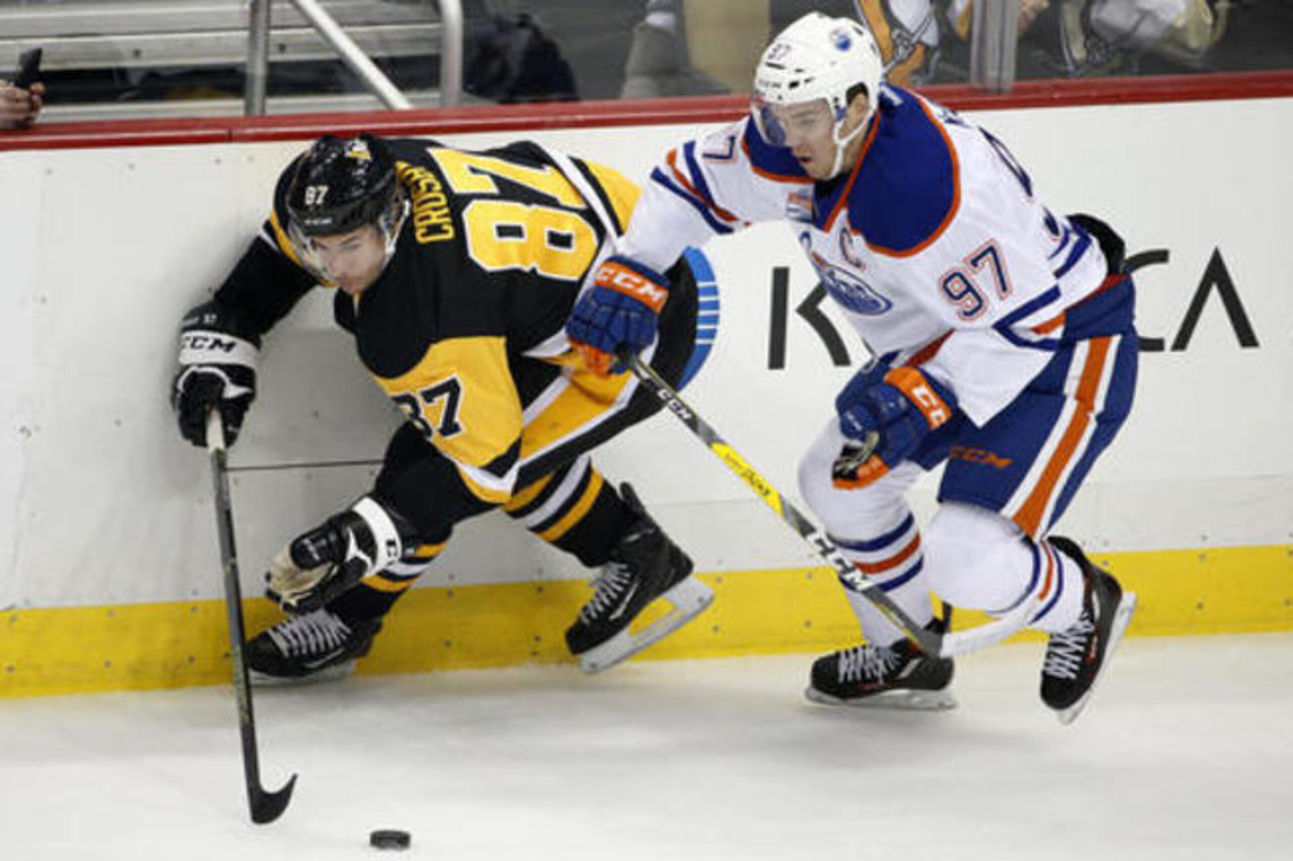 Edmonton Oilers' Connor McDavid (97) and Pittsburgh Penguins' Sidney Crosby (87) battle for the puck during the first period of an NHL hockey game in Pittsburgh, Tuesday, Nov. 8, 2016. (AP Photo/Gene J. Puskar)