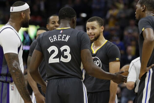 Golden State Warriors guard Stephen Curry, second from right, talks with teammate Draymond Green after he was called for a technical foul during the third quarter of an NBA basketball game against the Sacramento Kings Saturday, Feb. 4, 2017, in Sacramento, Calif. The Kings won in overtime 109-106. (AP Photo/Rich Pedroncelli)