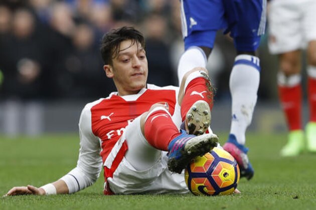Arsenal's Mesut Ozil controls the ball after slipping on the ground during the English Premier League soccer match between Chelsea and Arsenal at Stamford Bridge stadium in London, Saturday, Feb. 4, 2017. (AP Photo/Frank Augstein)