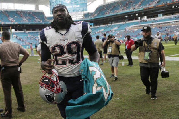 New England Patriots running back LeGarrette Blount (29) walks off the field with Miami Dolphins running back Jay Ajayi's shirt at the end of an NFL football game, Sunday, Jan. 1, 2017, in Miami Gardens, Fla. The Patriots defeated the Dolphins 35-14. (AP Photo/Lynne Sladky)