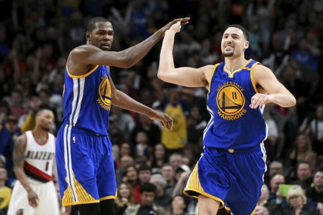 Golden State Warriors guard Klay Thompson celebrates with Golden State Warriors forward Kevin Durant after hitting a shot late in the fourth quarter of an NBA basketball game against the Portland Trail Blazers in Portland, Ore., Sunday, Jan. 29, 2017. The Warriors won the game 113-111. (AP Photo/Steve Dykes)