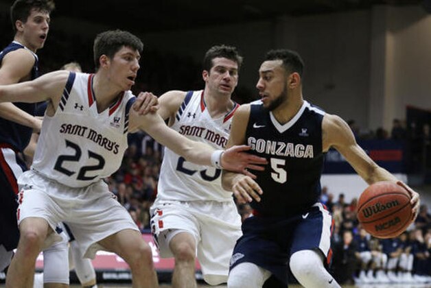 Gonzaga's Nigel Williams-Goss, right, drives the ball against Saint Mary's Dane Pineau (22) and Joe Rahon, center, during the first half of an NCAA college basketball game Saturday, Feb. 11, 2017, in Moraga, Calif. (AP Photo/Ben Margot)