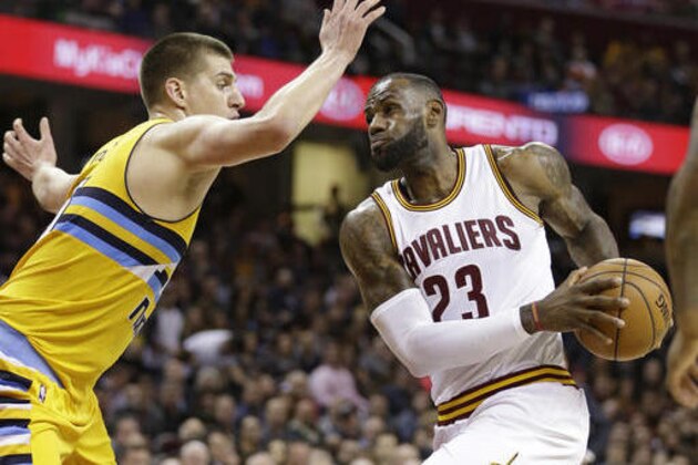 Cleveland Cavaliers' LeBron James, right, drives past Denver Nuggets' Nikola Jokic, from Serbia, in the first half of an NBA basketball game, Saturday, Feb. 11, 2017, in Cleveland. (AP Photo/Tony Dejak)