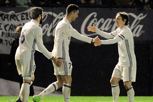 (L-R) Real Madrid's defender Nacho Fernandez, Portuguese forward Cristiano Ronaldo and Croatian midfielder Luka Modric celebrate after forward Lucas Vazquez scoring his team's third goal during the Spanish league football match CA Osasuna vs Real Madrid CF at El Sadar stadium in Pamplona on February 11, 2017. / AFP / ANDER GILLENEA        (Photo credit should read ANDER GILLENEA/AFP/Getty Images)