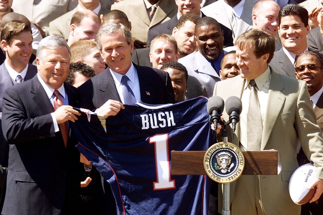 WASHINGTON, :  US President George W. Bush (L) participates in a photo opportunity 02 April, 2002 with the 2002 National Football League Super Bowl Champion New England Patriots in the Rose Garden of The White House in Washington, DC.  Bush was presented with a Patriots Jersey by Patriots owner Robert Kraft (L) and coach Bill Belichick (R). AFP PHOTO/Luke Frazza (Photo credit should read LUKE FRAZZA/AFP/Getty Images)