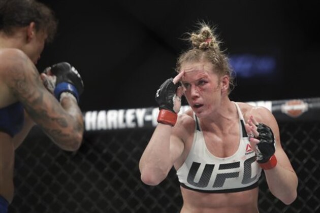 Holly Holm, right, fights Germaine de Randamie, of the Netherlands, during a women's featherweight championship mixed martial arts bout at UFC 208 Sunday, Feb. 12, 2017, in New York. de Randamie won the fight. (AP Photo/Frank Franklin II)