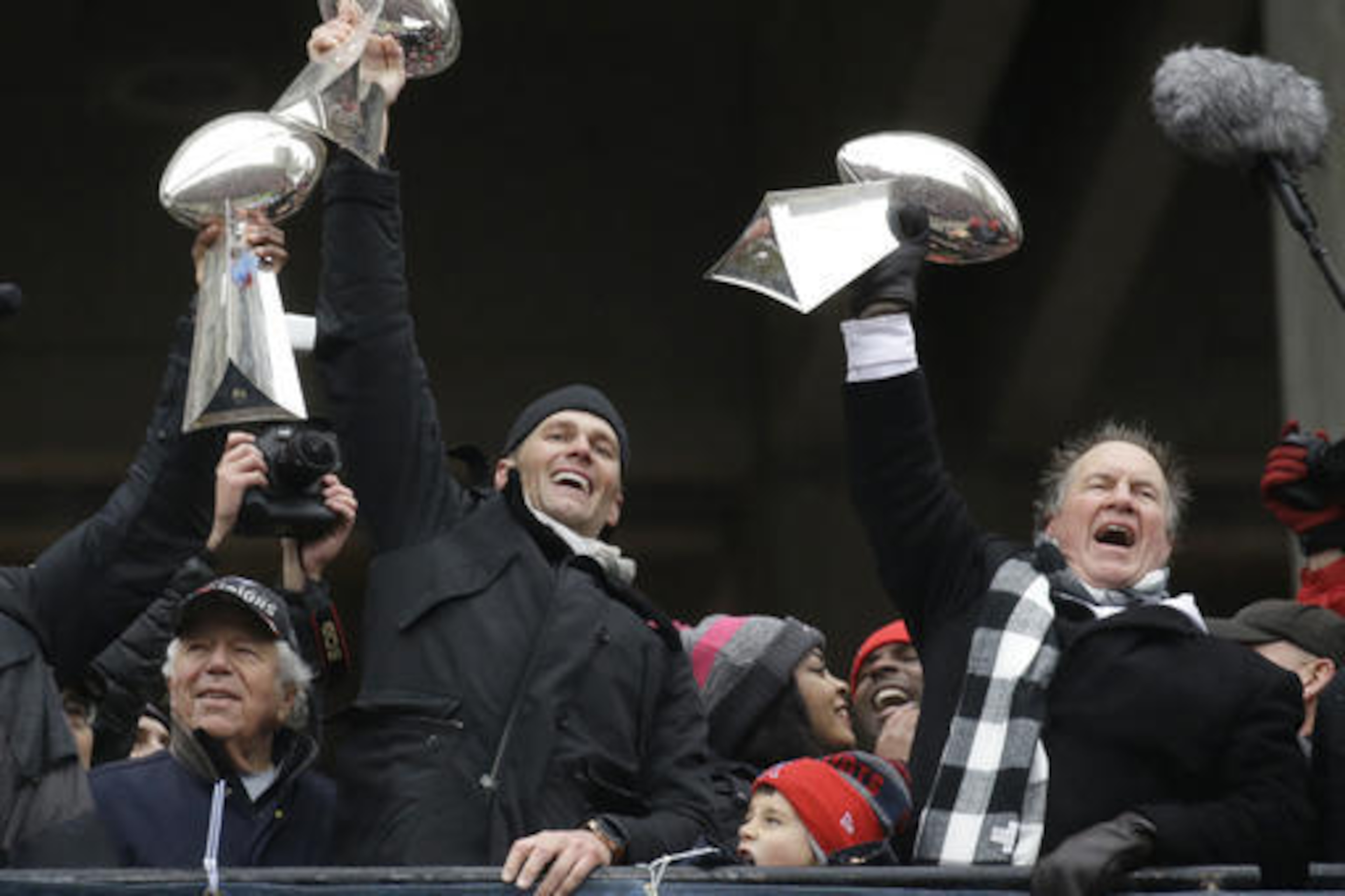 New England Patriots quarterback Tom Brady holds up Super Bowl trophies along with head coach Bill Belichick, right, and team owner Robert Kraft, left, during a rally Tuesday, Feb. 7, 2017, in Boston, to celebrate Sunday's 34-28 win over the Atlanta Falcons in the NFL Super Bowl 51 football game in Houston. (AP Photo/Elise Amendola)