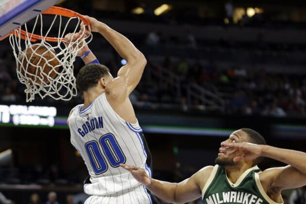 Orlando Magic's Aaron Gordon (00) dunks the ball behind his head after getting past Milwaukee Bucks' Jabari Parker (12) during the second half of an NBA basketball game, Friday, Jan. 20, 2017, in Orlando, Fla. Orlando won 112-96. (AP Photo/John Raoux)
