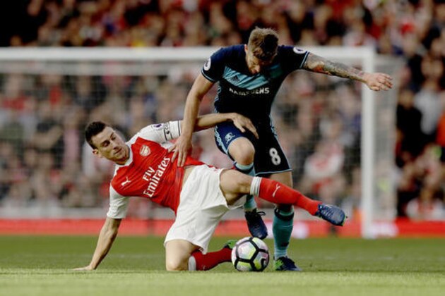 Arsenal's Laurent Koscielny, left, competes for the ball with Middlesbrough's Adam Clayton during the English Premier League soccer match between Arsenal and Middlesbrough at the Emirates Stadium in London, Saturday, Oct. 22, 2016. (AP Photo/Matt Dunham)