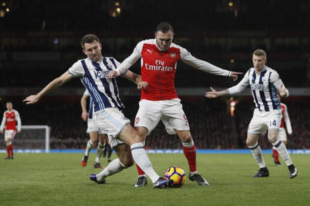 Arsenal's Lucas Perez, centre, vies for the ball with West Brom's Gareth McAuley during the English Premier League soccer match between Arsenal and West Bromwich Albion at Emirates stadium in London, Monday, Dec. 26, 2016. (AP Photo/Kirsty Wigglesworth)