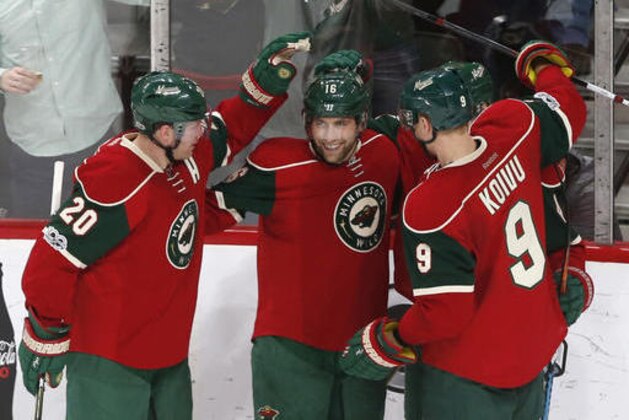 Minnesota Wild's Jason Zucker, center, celebrates his goal off Nashville Predators goalie Pekka Rinne, of Finland, with teammates during the second period of an NHL hockey game, Saturday, Feb. 18, 2017, in St. Paul, Minn. (AP Photo/Jim Mone)
