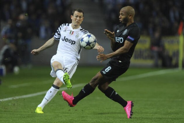 Juventus' Stephan Lichtsteiner, left, kicks the ball away from Porto's Yacine Brahimi during the Champions League round of 16, first leg, soccer match between FC Porto and Juventus at the Dragao stadium in Porto, Portugal, Wednesday, Feb. 22, 2017. (AP Photo/Paulo Duarte)
