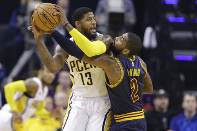 Cleveland Cavaliers guard Kyrie Irving (2) reaches around to defend Indiana Pacers forward Paul George (13) during the first half of an NBA basketball game in Indianapolis, Wednesday, Feb. 8, 2017. (AP Photo/Michael Conroy)