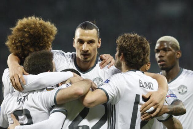Manchester United's Henrikh Mkhitaryan, center back to camera, celebrates scoring the opening goal with Zlatan Ibrahimovic, facing camera, and Paul Pogba, right, during a Europa League round of 32 second leg soccer match between Saint Etienne and Manchester United at Geoffroy Guichard stadium in Saint Etienne, France, Wednesday, Feb. 22, 2017. (AP Photo/Laurent Cipriani)
