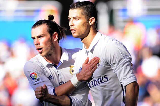 Real Madrid's Portuguese forward Cristiano Ronaldo (R) is congratulated by Welsh forward Gareth Bale (L) after scoring his team's first goal during the Spanish league football match between Deportivo Alaves and Real Madrid CF at the Mendizorroza stadium in Vitoria on October 29, 2016. / AFP / ANDER GILLENEA        (Photo credit should read ANDER GILLENEA/AFP/Getty Images)