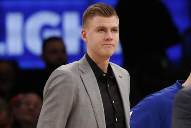 New York Knicks' forward Kristaps Porzingis, who is suffering from a sore left achilles, watches from the sideline in the second half of an NBA basketball game against the Milwaukee Bucks' at Madison Square Garden in New York, Wednesday, Jan. 4, 2017. The Bucks defeated the Knicks 105-104. (AP Photo/Kathy Willens)
