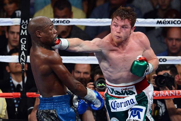 LAS VEGAS, NV - SEPTEMBER 14:  (R-L) Canelo Alvarez throws a right at Floyd Mayweather Jr. during their WBC/WBA 154-pound title fight at the MGM Grand Garden Arena on September 14, 2013 in Las Vegas, Nevada.  (Photo by Ethan Miller/Getty Images)