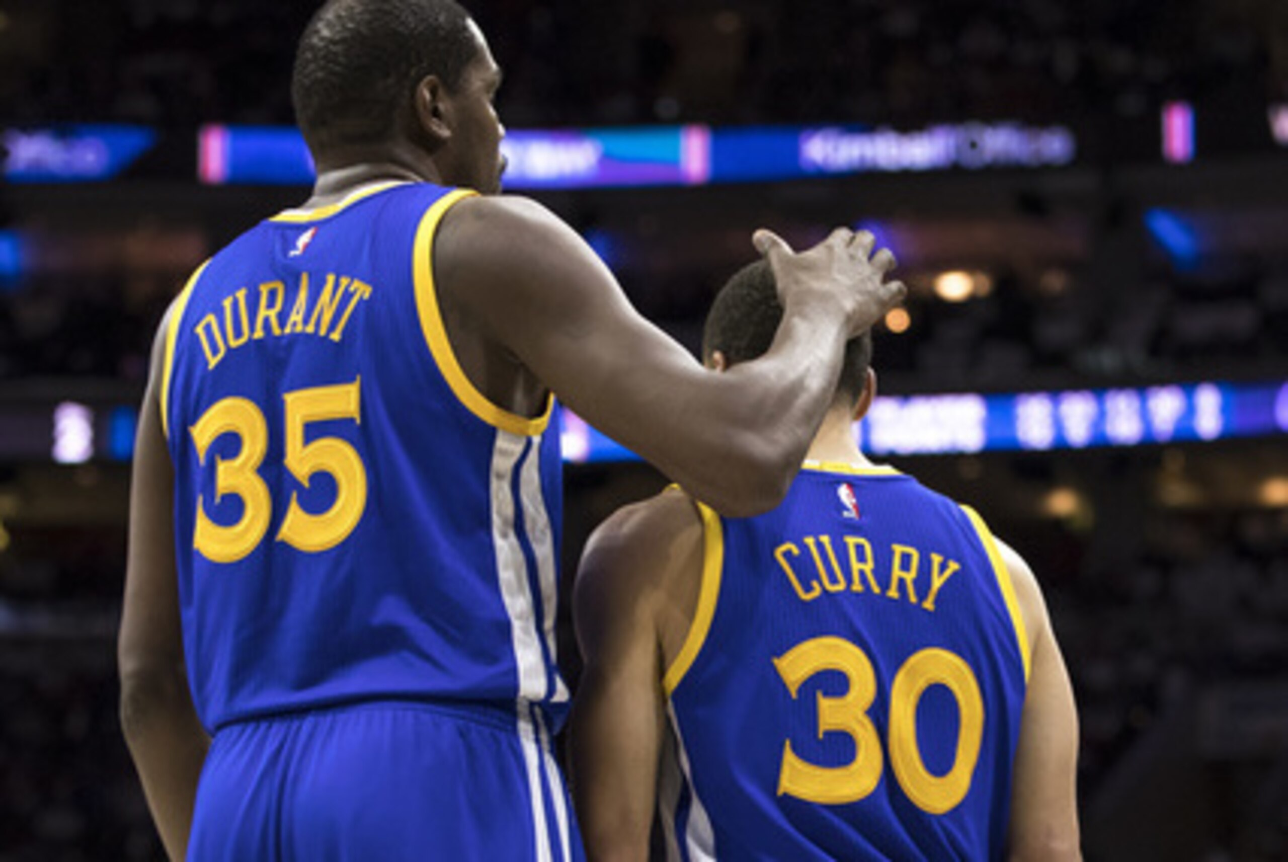 Golden State Warriors' Kevin Durant, left, pats Stephen Curry, right on the head after he misses the lay-up during the first half of an NBA basketball game against the Philadelphia 76ers, Monday, Feb. 27, 2017, in Philadelphia. (AP Photo/Chris Szagola)=