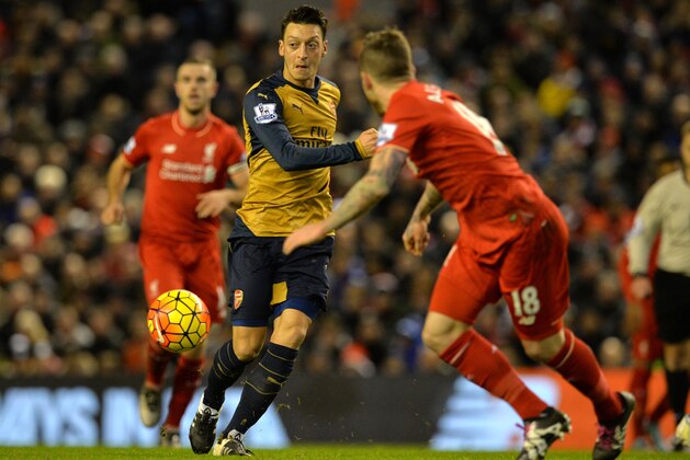 Arsenal's German midfielder Mesut Ozil (L) passes the ball during the English Premier League football match between Liverpool and Arsenal at Anfield stadium in Liverpool, north-west England on January 13, 2016.
AFP PHOTO / PAUL ELLIS
RESTRICTED TO EDITORIAL USE. NO USE WITH UNAUTHORIZED AUDIO, VIDEO, DATA, FIXTURE LISTS, CLUB/LEAGUE LOGOS OR 'LIVE' SERVICES. ONLINE IN-MATCH USE LIMITED TO 75 IMAGES, NO VIDEO EMULATION. NO USE IN BETTING, GAMES OR SINGLE CLUB/LEAGUE/PLAYER PUBLICATIONS. / AFP / PAUL ELLIS        (Photo credit should read PAUL ELLIS/AFP/Getty Images)
