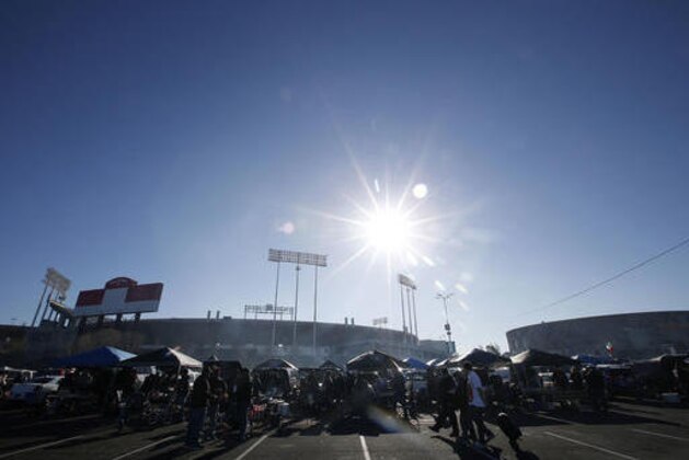 Fans tailgate at Oakland Alameda County Coliseum before an NFL football game between the Oakland Raiders and the Indianapolis Colts in Oakland, Calif., Saturday, Dec. 24, 2016. (AP Photo/Tony Avelar)