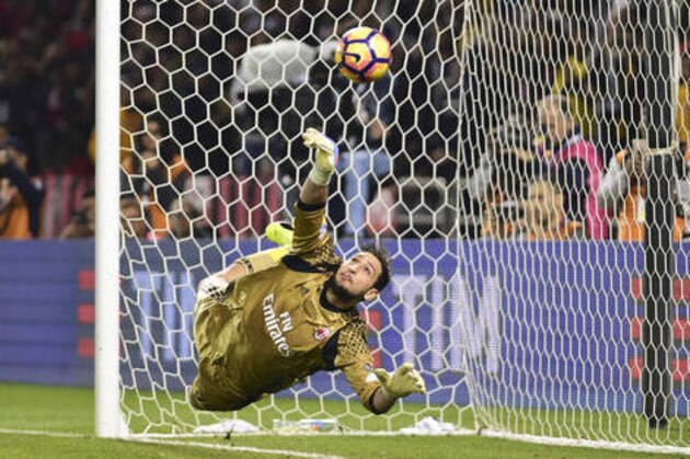 AC Milan goalkeeper Gianluigi Donnarumma saves a penalty during the Italian Super Cup soccer match between Juventus and AC Milan, at the Al Sadd Sports Club in Doha, Qatar, Friday, Dec. 23, 2016. AC Milan won 5-4 following a penalty shootout. (AP Photo/Alexandra Panagiotidou)