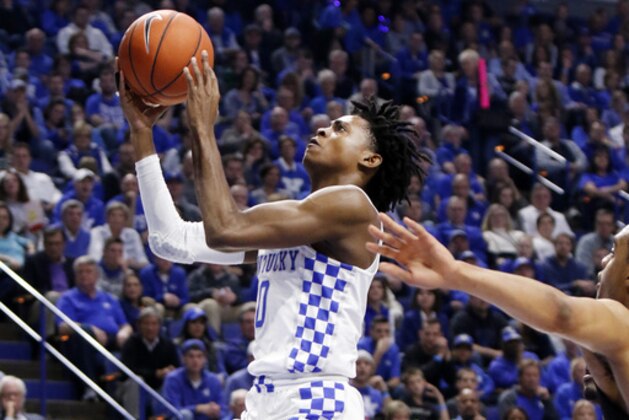 Kentucky's De'Aaron Fox, left, shots near Vanderbilt's Jeff Roberson during the first half of an NCAA college basketball game, Tuesday, Feb. 28, 2017, in Lexington, Ky. (AP Photo/James Crisp)