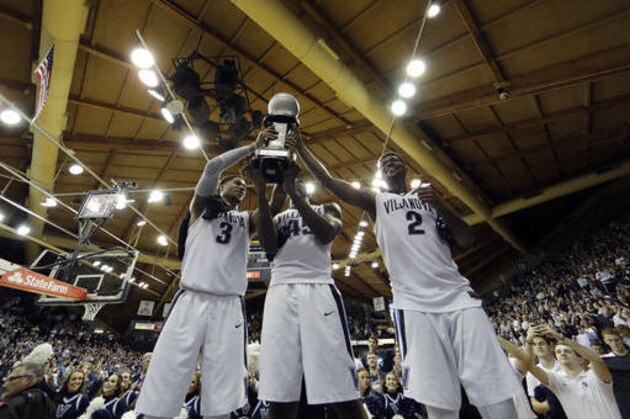 Villanova's Josh Hart, from left, Darryl Reynolds and Kris Jenkins celebrate with the Big East conference regular season trophy after winning an NCAA college basketball game against Creighton, 79-63, Saturday, Feb. 25, 2017, in Villanova, Pa. (AP Photo/Matt Slocum)